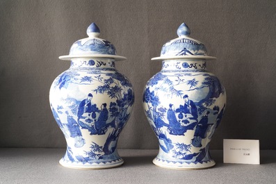 A pair of Chinese blue and white vases and covers with figures in a landscape, 19th C.