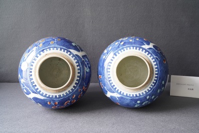 A pair of Chinese polychrome 'prunus on cracked ice' jars and covers, 19th C.