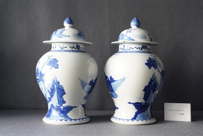 A pair of Chinese blue and white vases and covers with figures in a landscape, 19th C.