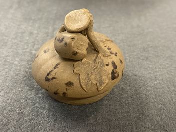 A bichrome Chinese Yixing stoneware teapot and cover with applied floral design, 19th C.