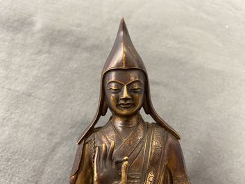 Een Sino-Tibetaanse vergulde bronzen figuur van een lama, 18/19e eeuw