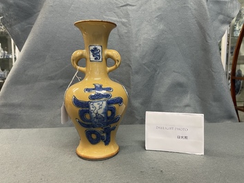 Un vase en porcelaine de Chine en bleu et blanc sur fond caf&eacute; au lait, Kangxi