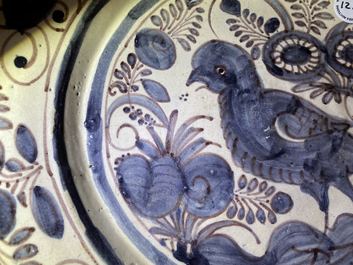 Un plat en fa&iuml;ence portugaise en bleu, blanc et mangan&egrave;se &agrave; d&eacute;cor d'un oiseau, 17&egrave;me