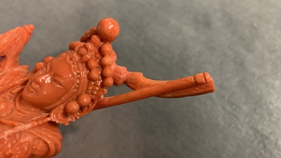 A Chinese carved red coral figure of a warrior holding a flag, 19/20th C.