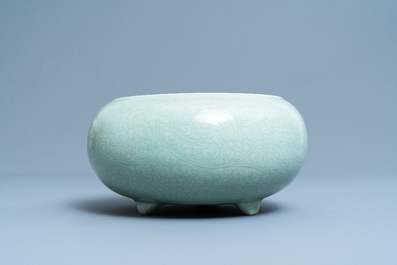 Een Chinese monochrome celadon driepotige wierookbrander met onderglazuur floraal decor, Kangxi