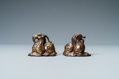 Two Chinese gilt and lacquered bronze 'mythical beast' scroll weights, late Ming