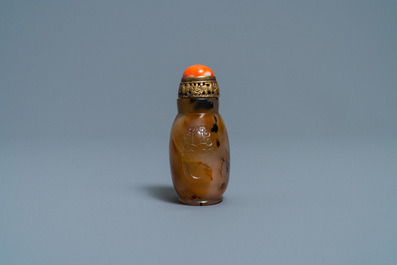 A Chinese agate snuff bottle with coral and gilt brass stopper, 19th C.