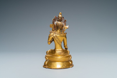 A Sino-Tibetan coral- and turquoise-inlaid gilt bronze figure of Tara, 18th C.