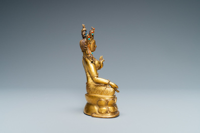 A Sino-Tibetan coral- and turquoise-inlaid gilt bronze figure of Tara, 18th C.