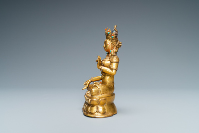 A Sino-Tibetan coral- and turquoise-inlaid gilt bronze figure of Tara, 18th C.