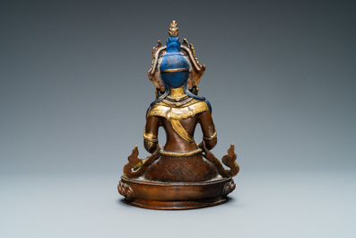 A Nepalese coral- and turquoise-inlaid partly gilded copper alloy figure of Buddha, 19/20th C.