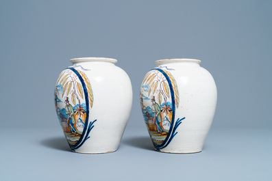 A pair of polychrome Dutch Delft tobacco jars with a merchant and a slave, late 18th C.