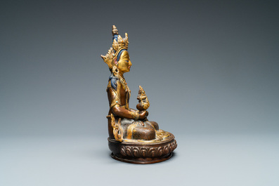 A Nepalese coral- and turquoise-inlaid partly gilded copper alloy figure of Buddha, 19/20th C.