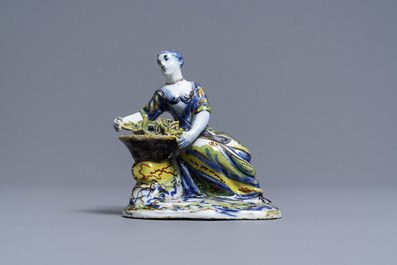 A polychrome Dutch Delft figure of a lady selling flowers, 18th C.