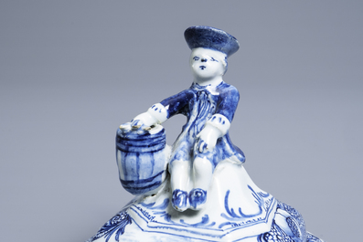 A Dutch Delft blue and white tobacco box and cover with a boy near a barrel, 18th C.