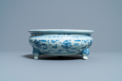 Een Chinese blauw-witte driepotige wierookbrander met floraal decor, Ming