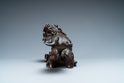 Un mod&egrave;le d'un lion bouddhiste en bronze sur socle en bois sculpt&eacute;, Chine, 18&egrave;me