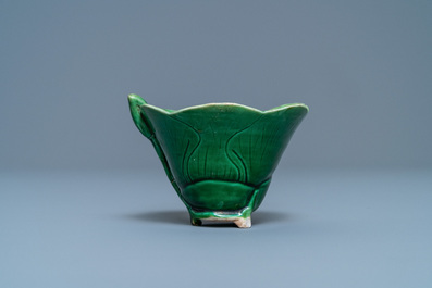 A Chinese 'egg and spinach'-glazed lotus cup and saucer with applied design, Kangxi