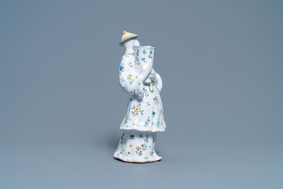 A polychrome French faience candle holder in the shape of a Chinaman, Lille, 18th C.