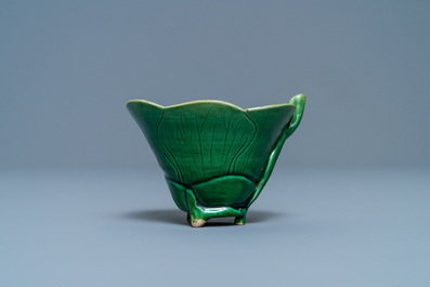 A Chinese 'egg and spinach'-glazed lotus cup and saucer with applied design, Kangxi