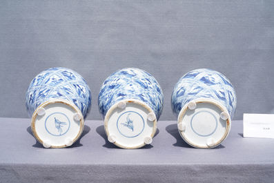 Une garniture de cinq vases en porcelaine de Chine en bleu et blanc aux panneaux floraux et de paysages, Kangxi
