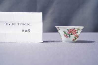 A Chinese famille rose 'tea scene' cup and saucer, Yongzheng/Qianlong