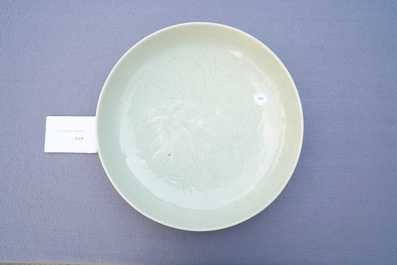 A Chinese monochrome celadon-glazed dish with underglaze floral design, 18/19th C.