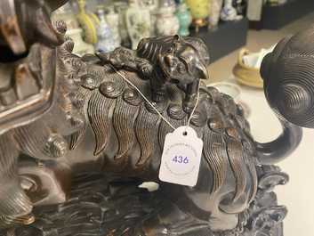 Un mod&egrave;le d'un lion bouddhiste en bronze sur socle en bois sculpt&eacute;, Chine, 18&egrave;me