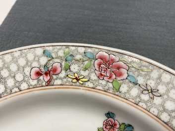 A Chinese famille rose plate with figures in an interior, Yongzheng