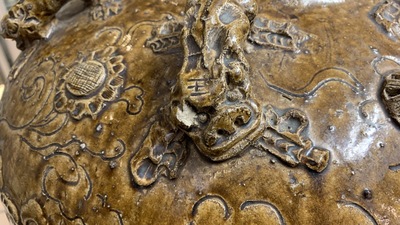Een grote Chinese bruin-geglazuurde martavaan met reli&euml;fdecor van boeddhistische leeuwen, Ming