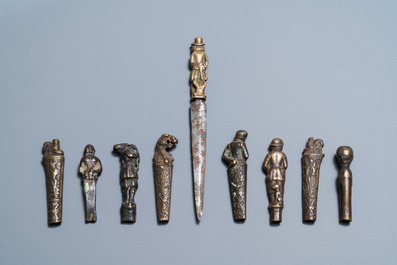 Nine bronze and brass knife handles including one with a knife, 16/18th C.