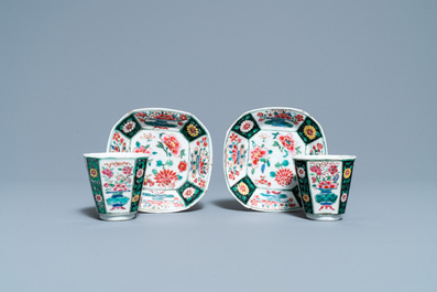 A pair of Chinese octagonal famille rose cups and saucers and a pair of verte biscuit dishes, Kangxi and Qianlong