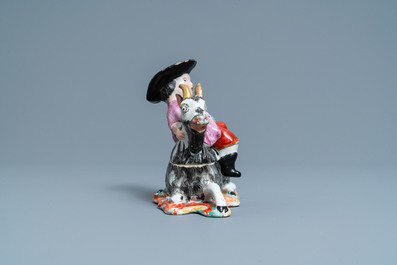 A polychrome Dutch Delft box and cover in the shape of a boy on a goat, 18th C.