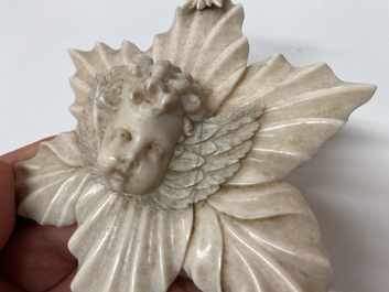 Un m&eacute;daillon de Christ et une t&ecirc;te d'angelot sur fond floral en ivoire, probablement France, fin du 18&egrave;me et vers 1900