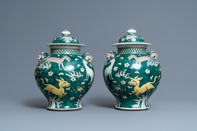 A pair of Chinese famille verte 'mythical animals' vases and covers, 19th C.