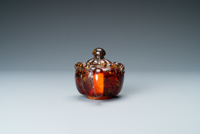 A Chinese carved amber teapot and cover on wooden 'lotus' stand, 19th C.