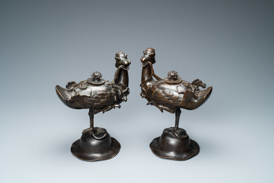 A pair of Chinese bronze censers modelled as ducks on a lotus flower, late Ming/early Qing