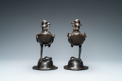 A pair of Chinese bronze censers modelled as ducks on a lotus flower, late Ming/early Qing