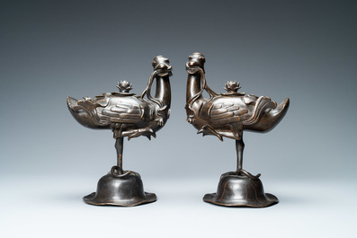 A pair of Chinese bronze censers modelled as ducks on a lotus flower, late Ming/early Qing