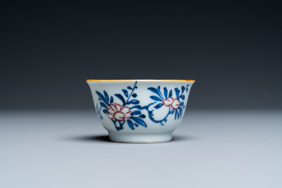 A Chinese blue, white and copper-red cup and saucer, Kangxi