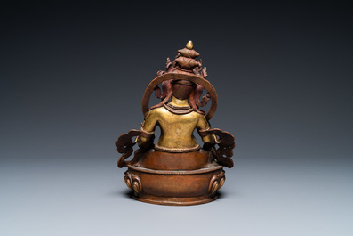 A Sino-Tibetan partly gilt bronze figure of Jambhala with inscriptions on the back, 19th C.