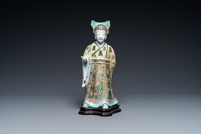 A Chinese famille verte figure on wooden stand, Kangxi