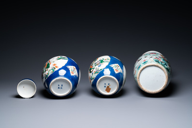 A Chinese famille rose vase and a pair of famille verte powder blue-ground jars, 19th C.