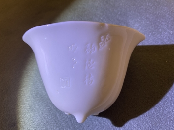 A Chinese Dehua blanc de Chine tripod wine cup with inscription, Kangxi