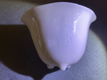 A Chinese Dehua blanc de Chine tripod wine cup with inscription, Kangxi