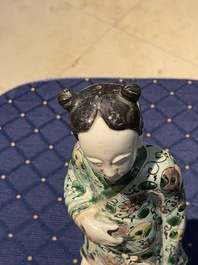 Een Chinese famille verte biscuit figuur, een groene 'lotus' pot en een blauw-wit bord met figuratief decor, Kangxi en later