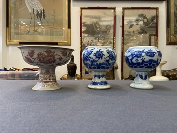 Une paire de bols sur piedouche en porcelaine de Chine en bleu et blanc et un en rouge de cuivre, 19/20&egrave;me