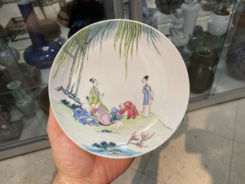 A Chinese famille rose cup and saucer with ladies and a boy playing with a rabbit, Yongzheng