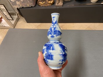 A Chinese blue and white double gourd vase with figures in a landscape, Transitional period