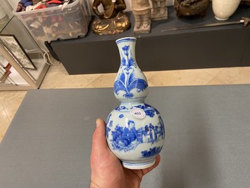 A Chinese blue and white double gourd vase with figures in a landscape, Transitional period